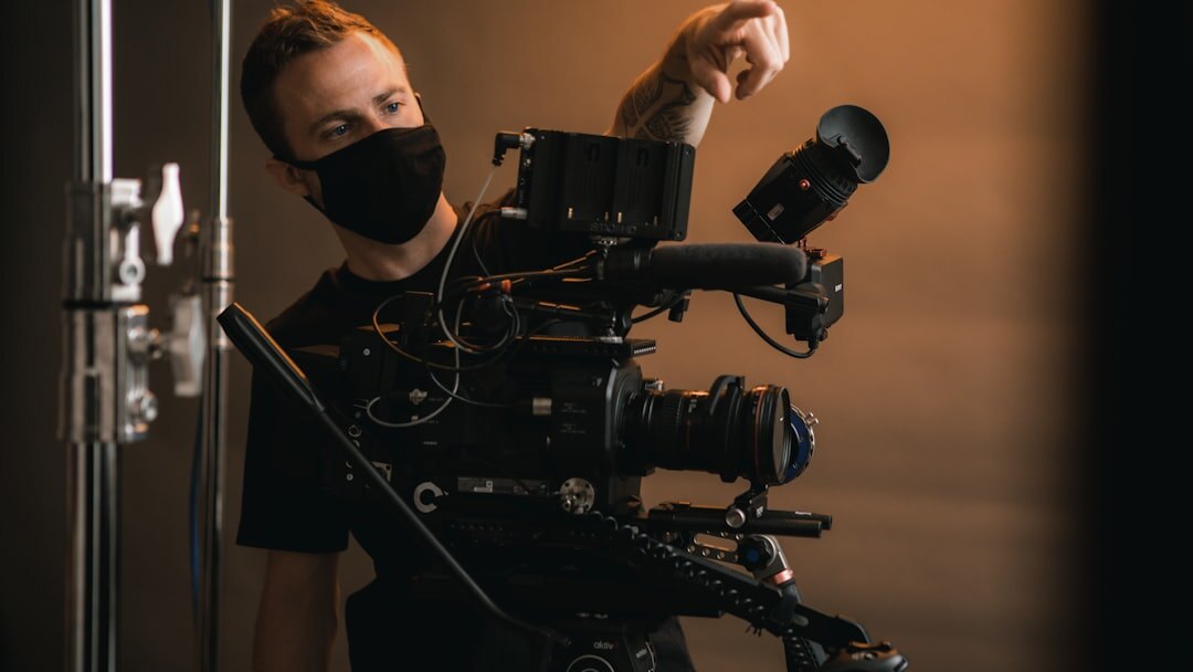 Camera operator behind a broadcast camera in a studio